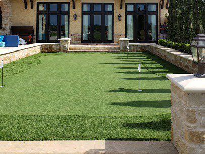Luxurious backyard artifical putting green installation provide by Helms Landscap of Houston Texas.