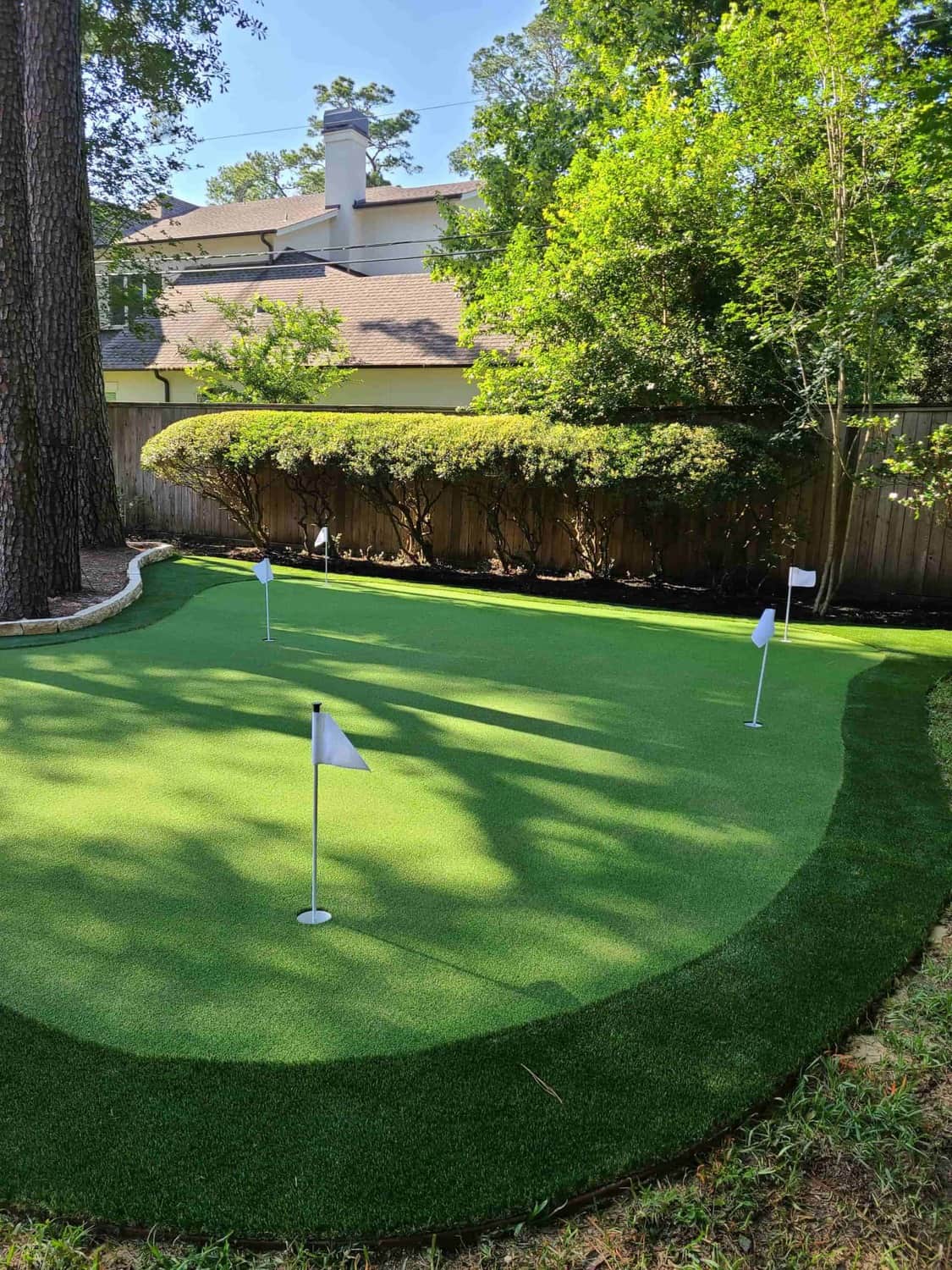 Beautiful small space backyard putting green installation with high-quality artificial turf